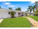 Inviting single-story home with a brick pathway leading to the front door and a manicured lawn at 2311 Sunnyside Pl, Sarasota, FL 34239