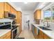 Well-lit kitchen featuring wood cabinets, stainless steel appliances, and ample counter space at 2311 Sunnyside Pl, Sarasota, FL 34239