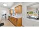 Functional kitchen with wooden cabinets, stainless steel dishwasher, and a view of the pool outside at 2311 Sunnyside Pl, Sarasota, FL 34239