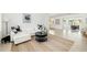 Open-concept living room with white sectional sofa, black accents, and view into adjacent dining room at 2311 Sunnyside Pl, Sarasota, FL 34239