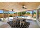 Enclosed patio with wood ceiling, fan, modern table set and view of pool and backyard at 2311 Sunnyside Pl, Sarasota, FL 34239
