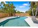 Relaxing pool with lounge chairs and a privacy fence surrounded by lush tropical landscaping at 2311 Sunnyside Pl, Sarasota, FL 34239