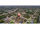 Drone shot of a residence in a neighborhood nestled among green trees with nearby roads and homes at 2366 Ann Arbor Rd, North Port, FL 34286