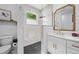 Modern bathroom featuring a tiled shower, shiplap, gold fixtures, and white cabinets at 2366 Ann Arbor Rd, North Port, FL 34286