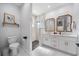Bathroom featuring double vanity with gold fixtures, shiplap wall accent, and marble shower with frameless glass at 2366 Ann Arbor Rd, North Port, FL 34286