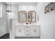 Bright bathroom featuring a double vanity, gold fixtures, shiplap wall, and marble shower with frameless glass door at 2366 Ann Arbor Rd, North Port, FL 34286