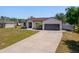 The front exterior of a single-Gathering home featuring a two car garage and long driveway at 2366 Ann Arbor Rd, North Port, FL 34286