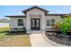 Inviting home entrance features a decorative glass double door, fresh landscaping, and a concrete walkway at 2366 Ann Arbor Rd, North Port, FL 34286