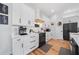 Modern kitchen featuring white cabinets, black hardware, stainless appliances, and bright countertops at 2366 Ann Arbor Rd, North Port, FL 34286