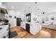 Bright kitchen with black stainless steel appliances, white cabinets, large island, and hardwood floors at 2366 Ann Arbor Rd, North Port, FL 34286