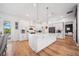 Well-lit kitchen featuring a large island, white cabinets, and direct access to outdoor living areas at 2366 Ann Arbor Rd, North Port, FL 34286