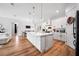 Modern kitchen features a large island, white cabinetry, stainless steel appliances, and pendant lighting at 2366 Ann Arbor Rd, North Port, FL 34286