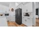 Well-lit kitchen with white cabinets, black appliances, and hardwood floors, creating a modern design at 2366 Ann Arbor Rd, North Port, FL 34286