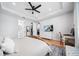 Bright bedroom with hardwood floors, tray ceiling, a ceiling fan, and access to ensuite bathroom and closet at 2366 Ann Arbor Rd, North Port, FL 34286