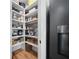 Organized walk-in pantry featuring shelving, storage baskets, countertop appliances, and hardwood floors at 2366 Ann Arbor Rd, North Port, FL 34286