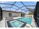 A covered screened-in pool and spa area outside this home features lounge seating at 2366 Ann Arbor Rd, North Port, FL 34286