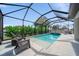 Inviting screened-in pool area with hot tub, comfortable seating, and lush landscaping at 2366 Ann Arbor Rd, North Port, FL 34286