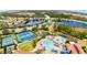An aerial view of community amenities, including tennis courts, a pool, and a playground by the lake at 2705 Taheebo Way, North Port, FL 34289