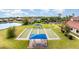 Aerial view of community bocce ball court and clubhouse with beautiful landscaping and pond views in a quiet neighborhood at 2705 Taheebo Way, North Port, FL 34289