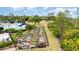 Aerial view of community garden, lush landscaping, and swimming pool amenities with palm trees on a sunny day at 2705 Taheebo Way, North Port, FL 34289