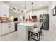 Bright kitchen featuring white cabinets, stainless steel appliances, and a large island with barstool seating at 2705 Taheebo Way, North Port, FL 34289