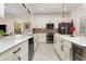 Modern kitchen with white cabinets, stone countertops, stainless steel appliances at 2705 Taheebo Way, North Port, FL 34289