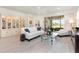 Spacious living room with a glass coffee table, white sofa, and a view of the enclosed lanai at 2705 Taheebo Way, North Port, FL 34289
