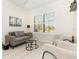 Comfortable living room featuring a neutral color palette and natural light from large window at 2705 Taheebo Way, North Port, FL 34289