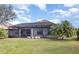 Rear exterior view showcasing a screened-in lanai, pool, and well-maintained lawn, perfect for outdoor living at 2705 Taheebo Way, North Port, FL 34289