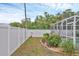Well-maintained backyard with a white fence, lush landscaping, and screened-in patio at 2715 52Nd Avenue W Ter, Bradenton, FL 34207