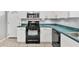 Well-lit kitchen with black oven range, white cabinets, and teal countertops at 2715 52Nd Avenue W Ter, Bradenton, FL 34207