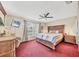 Spacious main bedroom with plush red carpeting, large bed, and a ceiling fan at 2715 52Nd Avenue W Ter, Bradenton, FL 34207