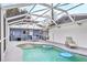 Backyard kidney-shaped pool with patio including screened in enclosure and lounge chairs at 2715 52Nd Avenue W Ter, Bradenton, FL 34207