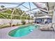 Backyard kidney-shaped pool area enclosed with a screened-in patio and a lounge chair at 2715 52Nd Avenue W Ter, Bradenton, FL 34207
