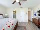 Comfortable bedroom with hardwood floors, a ceiling fan, dresser, and decorative wall art at 3500 Beneva Rd # 306, Sarasota, FL 34232
