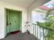 Entrance featuring a bright green door, welcome mat, table with flowers, and green railing leading to the unit at 3500 Beneva Rd # 306, Sarasota, FL 34232