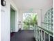 Hallway entrance featuring a bright green door, small table with flowers, green railings, and an exit sign at 3500 Beneva Rd # 306, Sarasota, FL 34232
