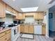 Well-lit kitchen features wood cabinets, updated appliances, and a skylight that fills the room with natural light at 3500 Beneva Rd # 306, Sarasota, FL 34232
