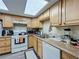 Kitchen features wooden cabinets, a white refrigerator and oven, and plenty of counter space at 3500 Beneva Rd # 306, Sarasota, FL 34232