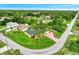 Stunning aerial view of a home with a green lawn, mature trees and landscaping in a desirable neighborhood at 3530 Adelaide Ave, North Port, FL 34288