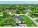 Aerial view showcases a charming home with pool, set within a lush landscape with mature trees at 3530 Adelaide Ave, North Port, FL 34288