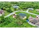 Aerial view highlighting a quaint home nestled among mature trees and landscaping, close to a serene river at 3530 Adelaide Ave, North Port, FL 34288
