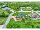 Panoramic aerial view of a home nestled within a lush, green neighborhood with mature trees and landscaping at 3530 Adelaide Ave, North Port, FL 34288