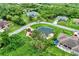 Aerial view highlighting a quaint home nestled among mature trees and landscaping, close to a serene river at 3530 Adelaide Ave, North Port, FL 34288