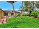 Spacious backyard featuring green grass, mature trees, and a screened lanai with a pool at 3530 Adelaide Ave, North Port, FL 34288