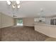 Open-concept living room with carpet flooring, ceiling fan, and sliding glass doors to a pool at 3530 Adelaide Ave, North Port, FL 34288