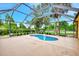 Screened pool with a safety fence surrounded by manicured landscaping at 3530 Adelaide Ave, North Port, FL 34288