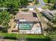 Aerial view of a home with a screened-in pool, fenced yard, and mature trees at 3600 Aster Dr, Sarasota, FL 34233