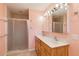 Bathroom featuring double sinks, wood cabinets and a glass enclosed shower at 3600 Aster Dr, Sarasota, FL 34233