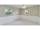 Bright bedroom featuring wainscotting, wallpaper, and two large windows at 3600 Aster Dr, Sarasota, FL 34233